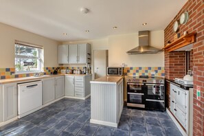 A compact kitchen with grey cabinets, a microwave, a stove, and an oven.