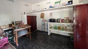 A compact kitchen with a microwave, toaster, and various kitchen items on shelves.