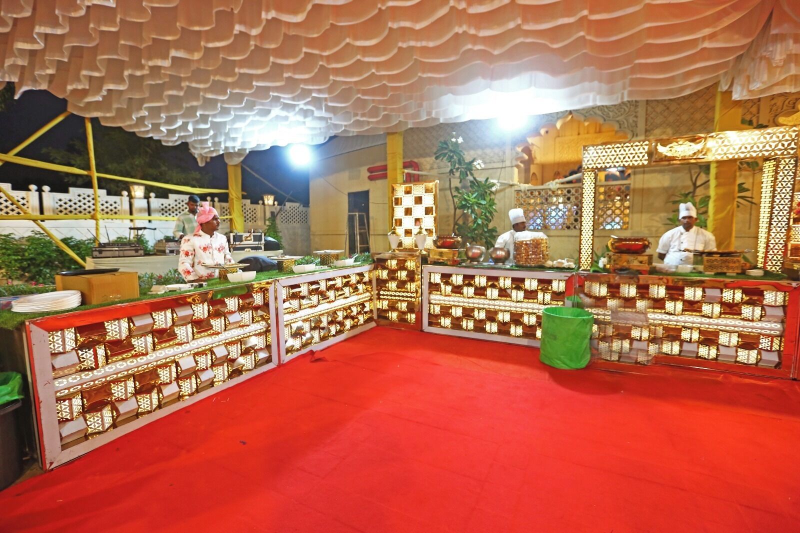 A decorated event space with a red carpet, patterned barriers, and a stage area.