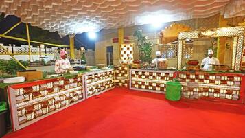 A decorated event space with a red carpet, patterned barriers, and a stage area.