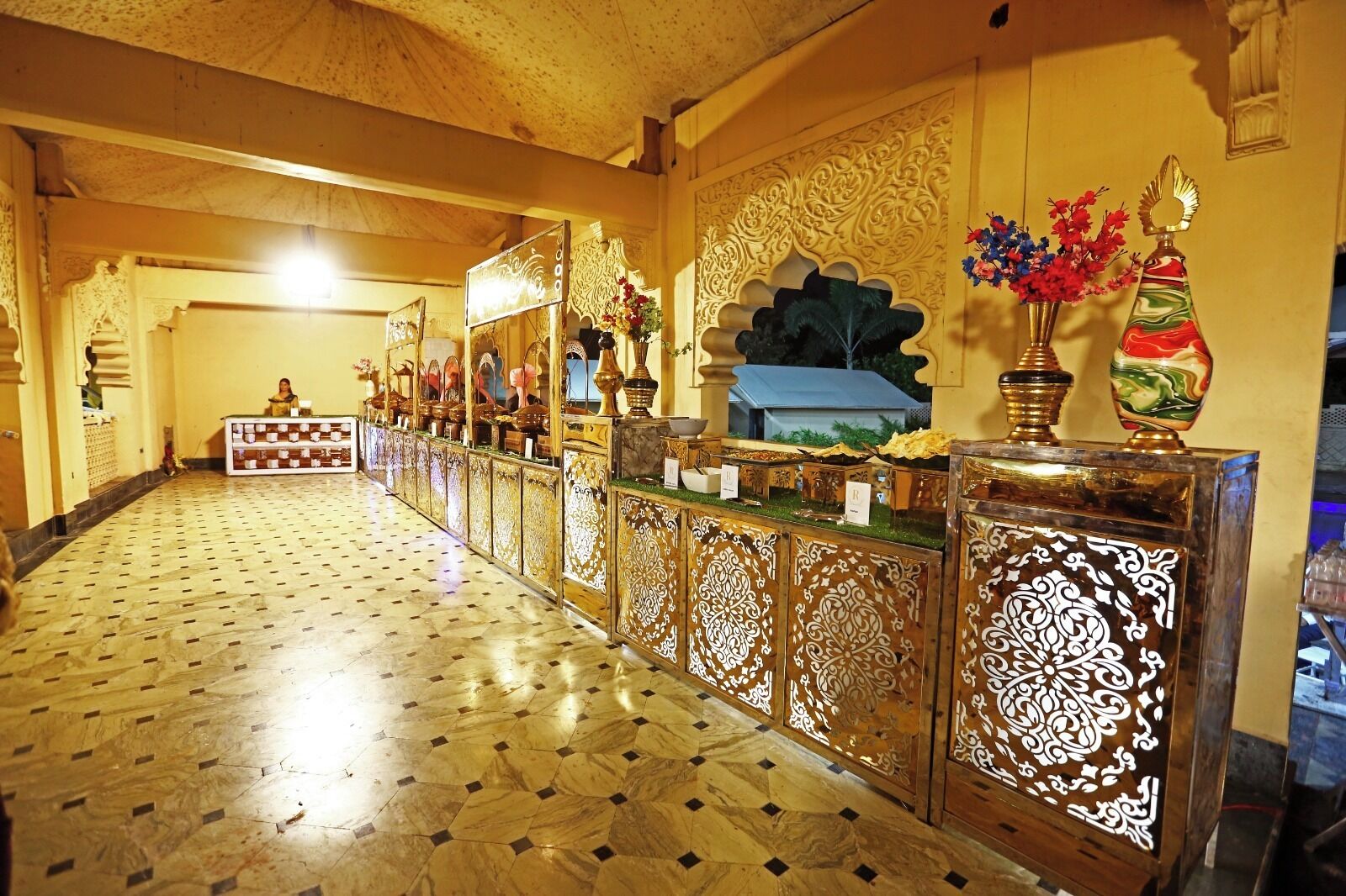 A hallway with ornate wooden paneling, a patterned floor, and decorative vases.