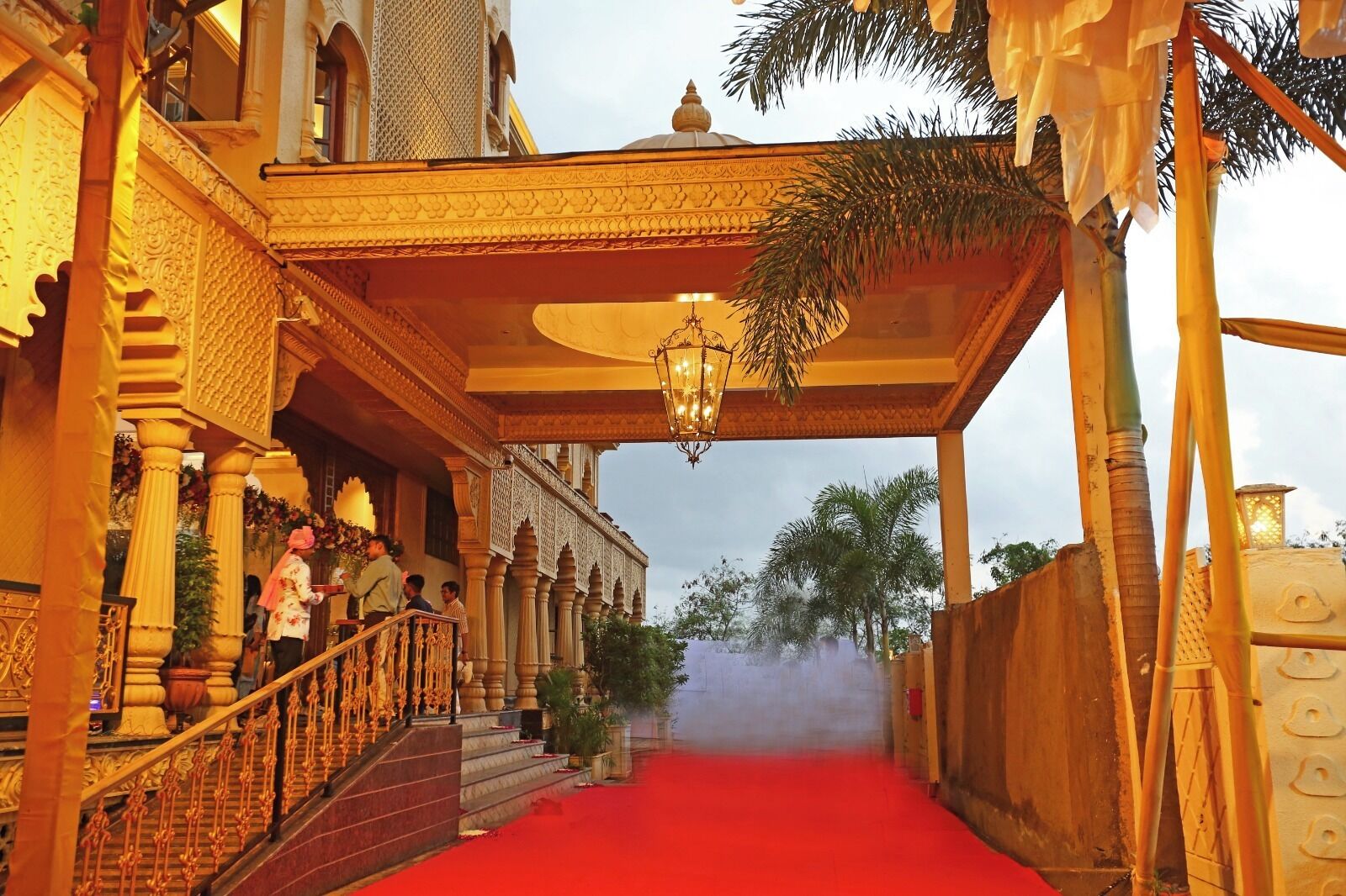 A grand entrance with a red carpet, ornate columns, and a covered walkway.