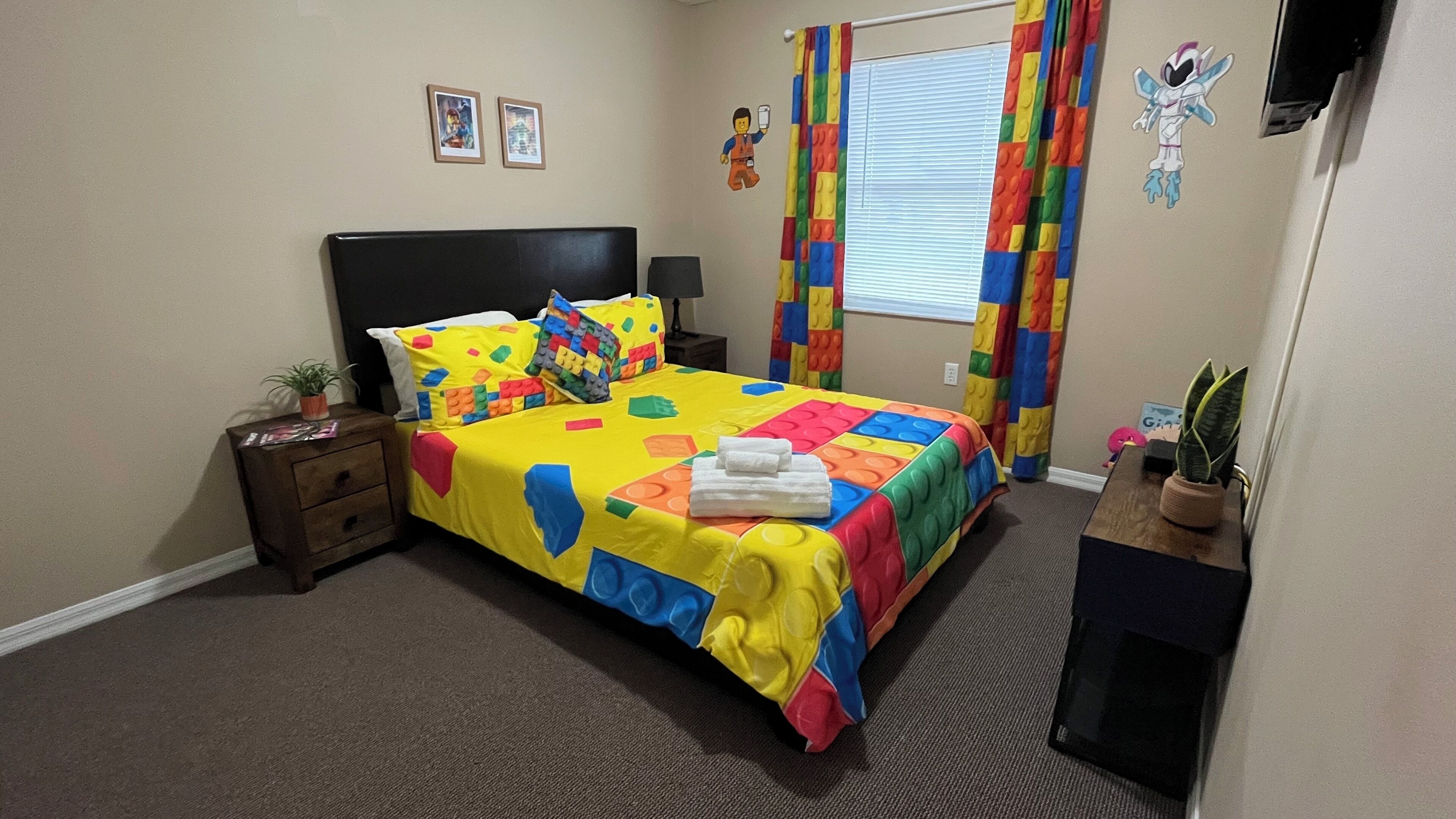 A bedroom with a bed, nightstand, lamp, and a window with curtains.