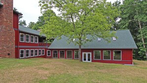 A red two-story building with a large tree in front.