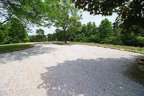 Un'area di parcheggio sterrata con alberi ed erba sullo sfondo.