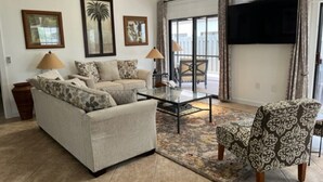 A living room with a sofa, armchairs, a coffee table, and a TV. - Fabulous Naples Townhouse in Desirable Pelican Ridge Location (Naples)