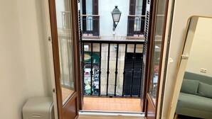 A view from a balcony with a wooden door, a black gate, and a green awning. - Pensión Miramar (San Sebastian)