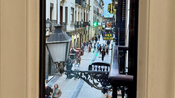 A street view with buildings, pedestrians, and a street lamp. - Pensión Miramar (San Sebastian)