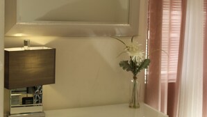 A room with a bedside lamp, a vase with flowers, and a window with curtains. - perfect getaway. sf view. free parking on site (Oakland)