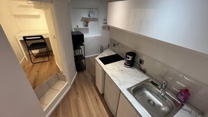 A compact kitchen with a sink, a coffee maker, and a small shelf. - Large American Studio (Toulon)