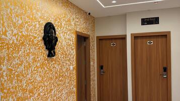 A hallway with a textured wall, two wooden doors, and a sign indicating the 2nd floor.