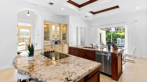 A spacious kitchen with a large island, built-in cabinetry, and a view to the outdoors.