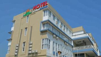 A hotel building with a prominent 'HOTEL' sign, multiple floors, and balconies.