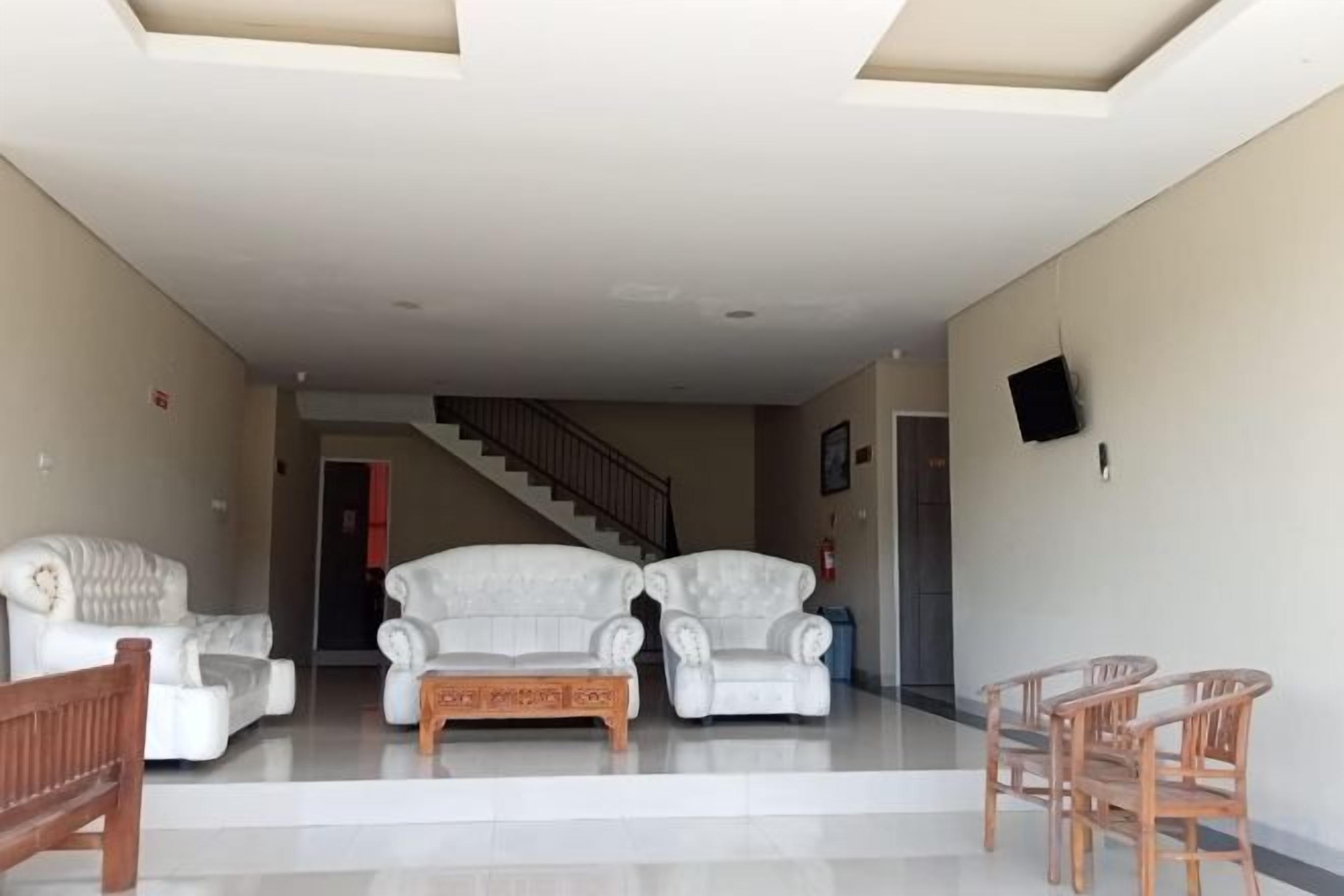 A spacious living area with a staircase leading to another level, a sofa set, and a small table.