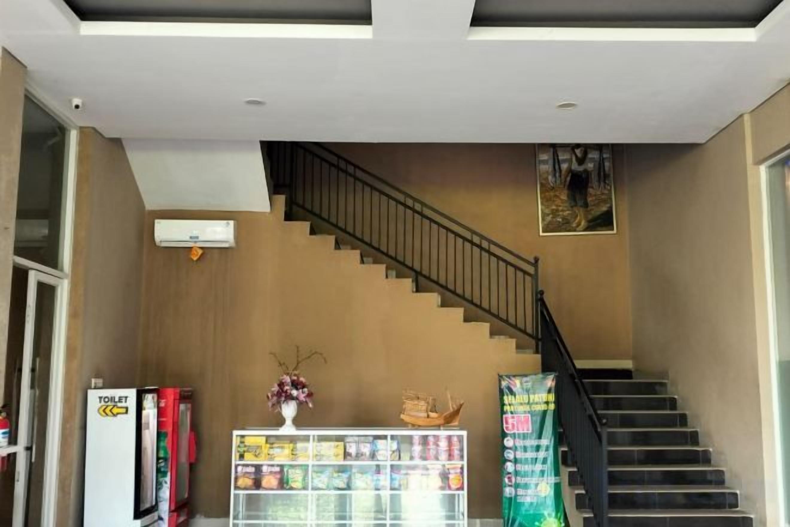 Una escalera con barandilla, una máquina expendedora y una exhibición de bocadillos.