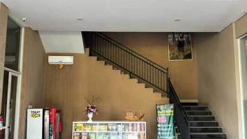 Una escalera con barandilla, una máquina expendedora y una exhibición de bocadillos.