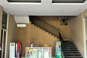 Μια σκάλα με κουπαστή, ένας αυτόματος πωλητής και μια προθήκη με σνακ.