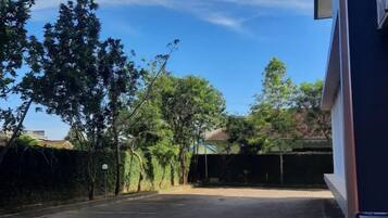 A parking lot with trees and a building in the background.