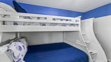 A bunk bed with a blue mattress and white headboard.