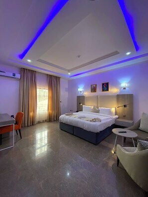 Une chambre d’hôtel moderne avec un grand lit, des tables de chevet, un bureau et une chaise.