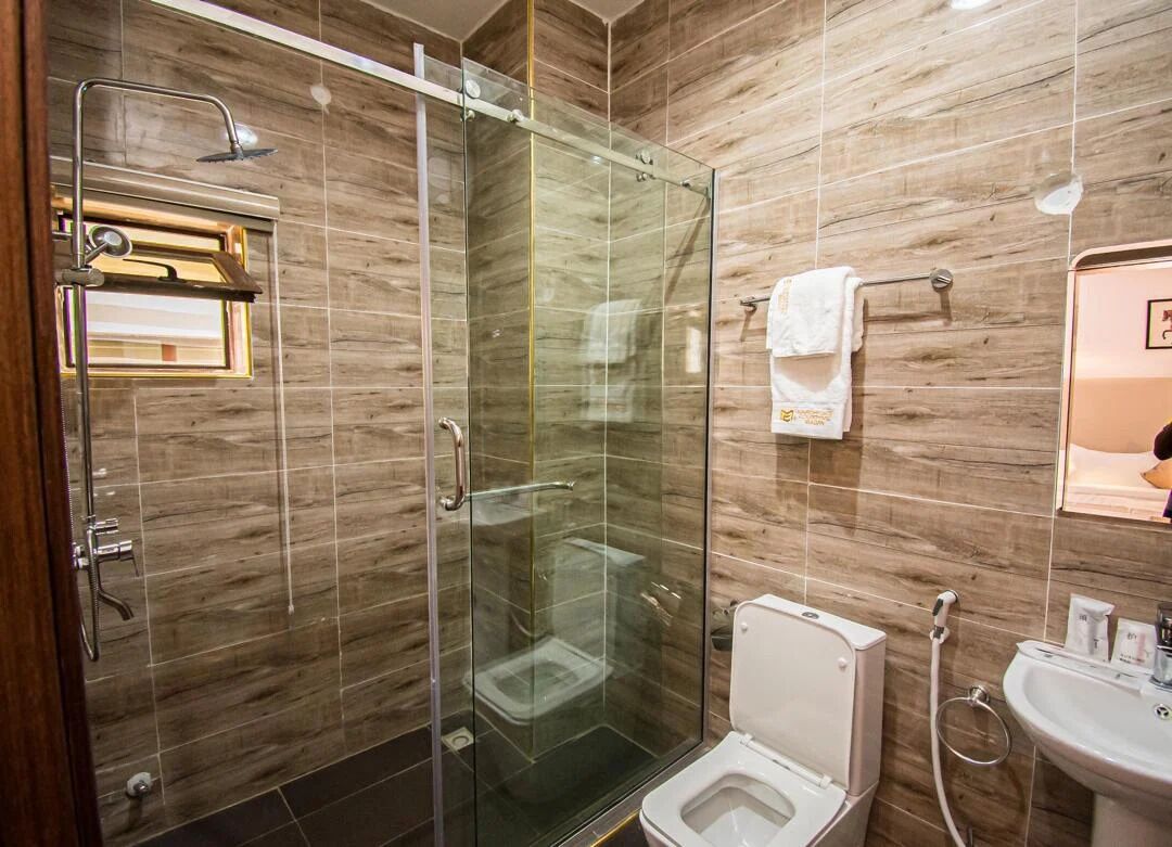 Un baño moderno con ducha envuelta en vidrio, inodoro y lavamanos.