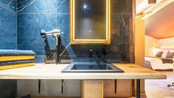 A modern bathroom with a marble backsplash, a large mirror, and a built-in sink.