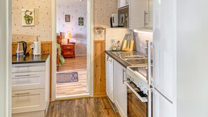 A compact kitchen with a dishwasher, a sink, and a stove. There is a wooden cabinet and a countertop. - 1 bedroom beautiful home in Tranås (Tranås)