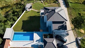 A modern house with a swimming pool, a covered patio, and a carport.