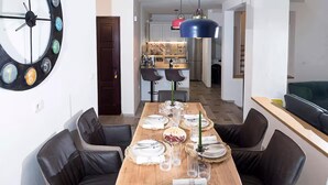 A dining area with a wooden table set for six, surrounded by black leather chairs.