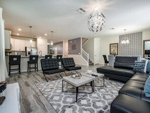 Relax in this stylish living room with a black leather sofa, armchair, and patterned rug.