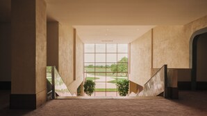 Un interior amplio con vistas a un jardín a través de grandes ventanales.