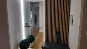 Een modern interieur met een glazen scheidingswand, een wand van houten latten en een klein groen plantje.