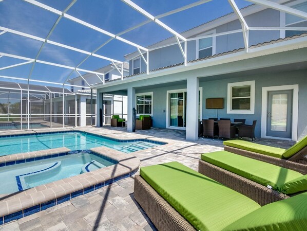 Un espace piscine couvert avec des chaises longues et une table de patio.