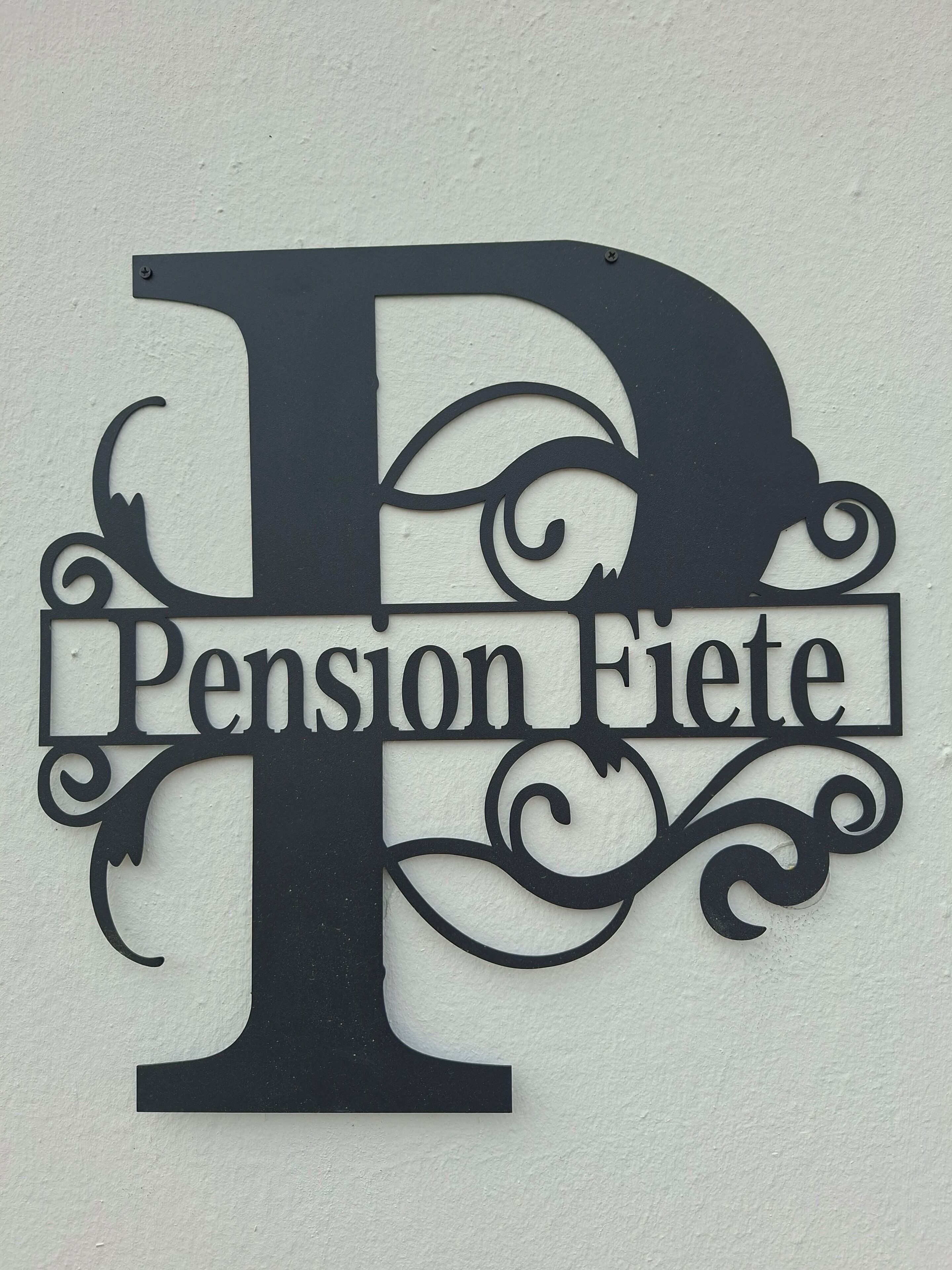 Un letrero metálico decorativo con la letra 