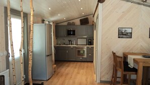 Cocina compacta con refrigerador, microondas y horno.