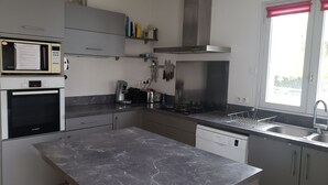 A modern kitchen with a Bosch oven, a coffee maker, and a dishwasher. - La Baule beach 1.5 km away. Bright house sleeps 9, enclosed garden  (Guérande)