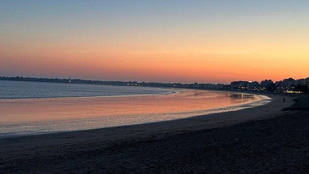 A beach at sunset with a calm sea, a sandy shore, and distant buildings. - La Baule beach 1.5 km away. Bright house sleeps 9, enclosed garden  (Guérande)