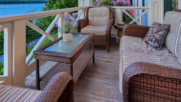A covered porch with wicker furniture, a table, and a ceiling fan. - THE RIVERFRONT BOATHOUSE (York)