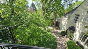 Jardí residencial amb un camí de pedra, gespa i una casa de façana blanca.