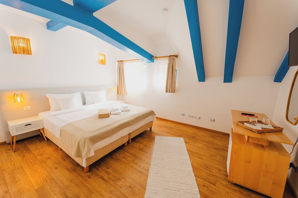 A bedroom with a bed, bedside table, and a wooden dresser.