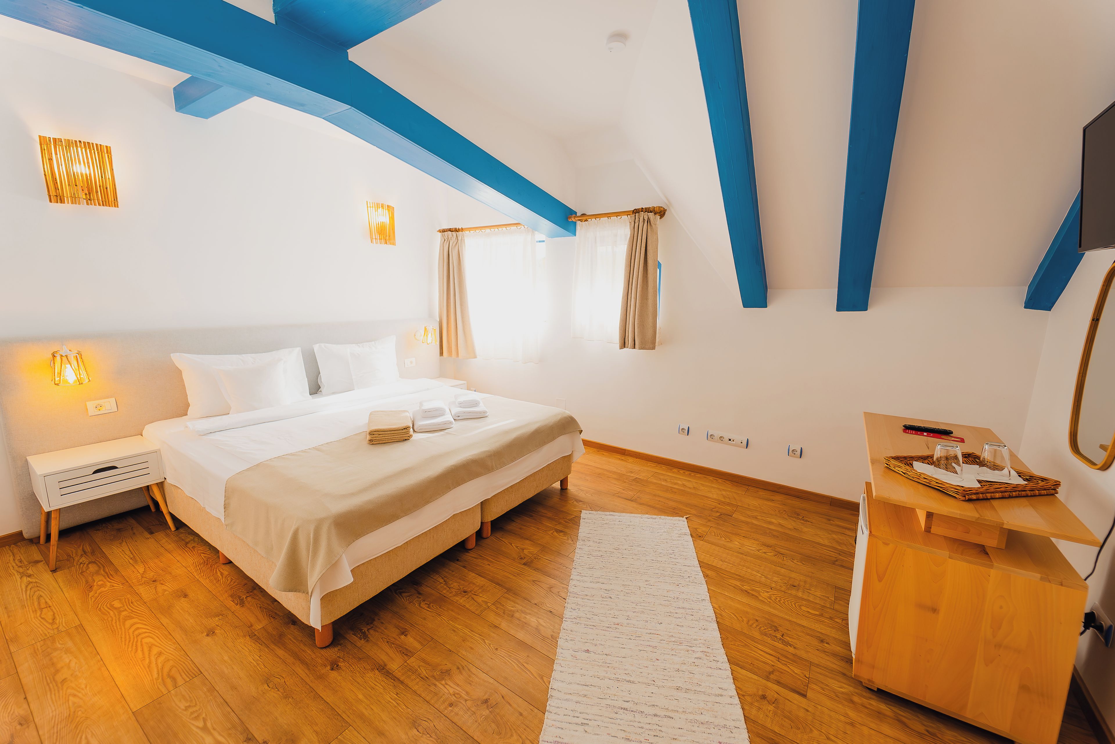 Une chambre à coucher avec un lit, une table de chevet et une commode en bois.