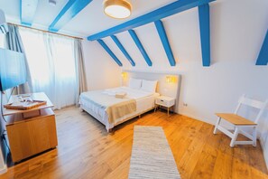 A bedroom with a bed, bedside tables, a chair, a desk, and a TV. - Cherhana Resort (Crisan)