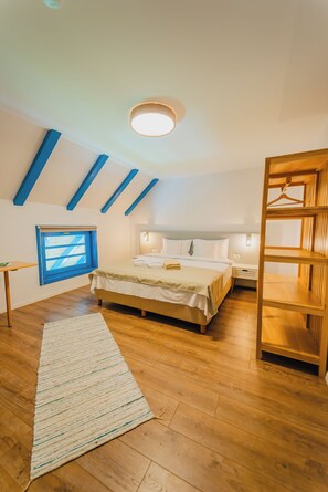 A bedroom with a bed, bedside table, and a wooden shelf unit.