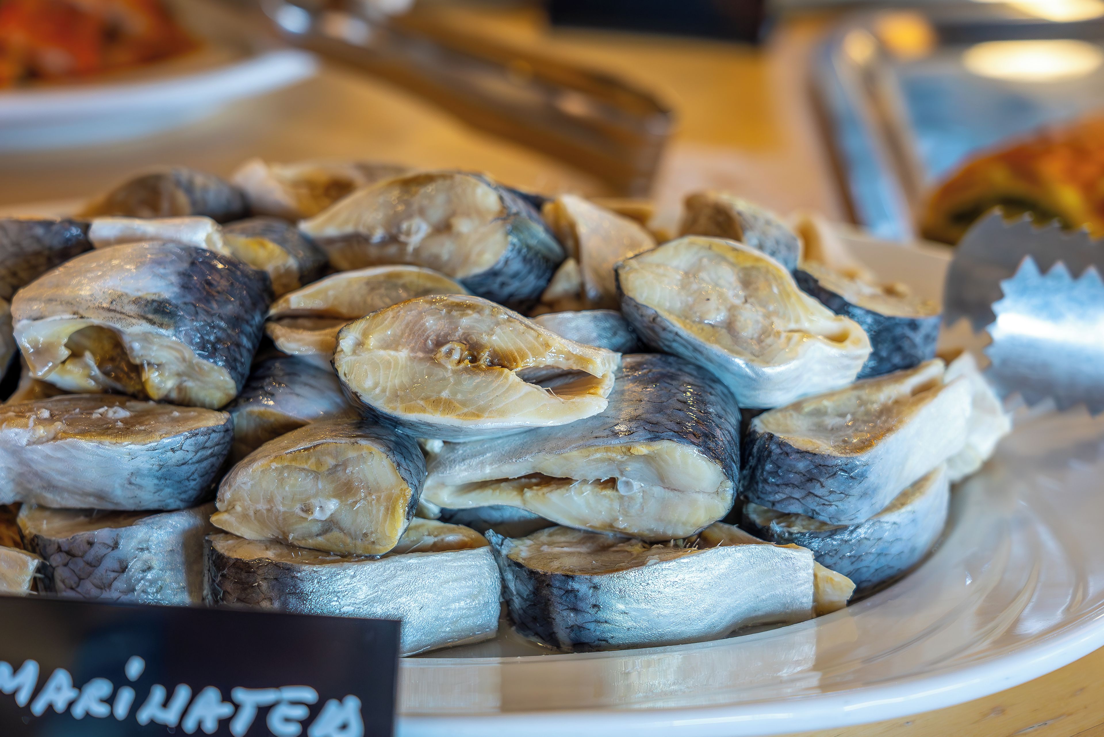 A plate of marinated fish, likely prepared for cooking or serving.