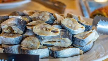 A plate of marinated fish, likely prepared for cooking or serving.