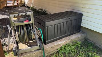 A utility box and a hose connected to it, placed on a concrete step next to a house.