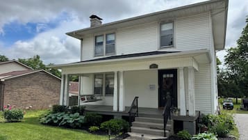A two-story house with a porch, a front door, and a number '410' sign.