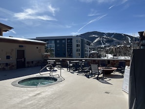 An outdoor pool area with a hot tub, lounge chairs, and a view of a mountain range. - Ski-In/Ski-Out 3BR/Canyons Village/Private Balcony (Park City)