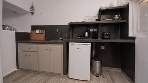 A compact kitchen with a dishwasher, a coffee maker, and a sink.
