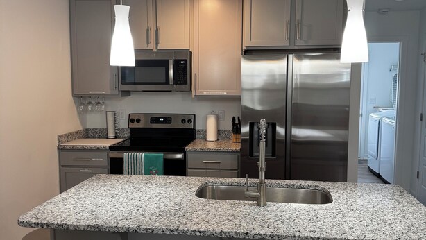 A modern kitchen with granite countertops, stainless steel appliances, and pendant lighting. -  3-bedroom bungalow with , WiFi in Jeffersonville (Jeffersonville)
